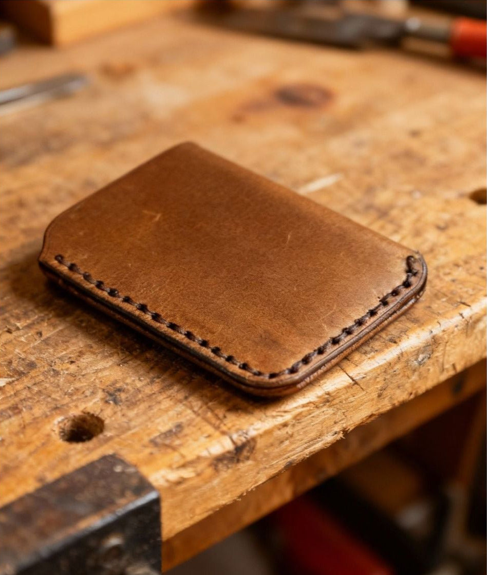 Brown leather wallet on a wooden workbench